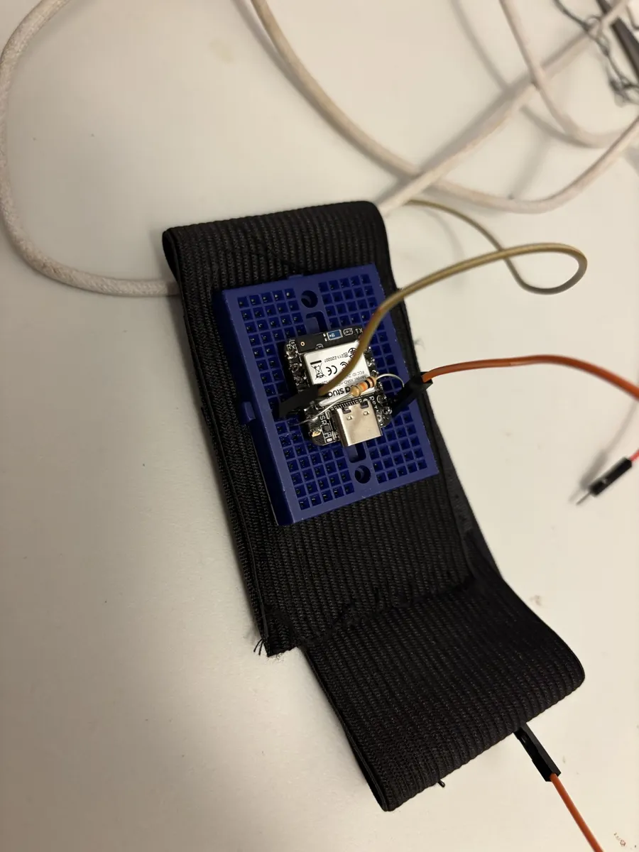 V1 prototype: XIAO nRF52840 on a breadboard, sewn to a stretch strap